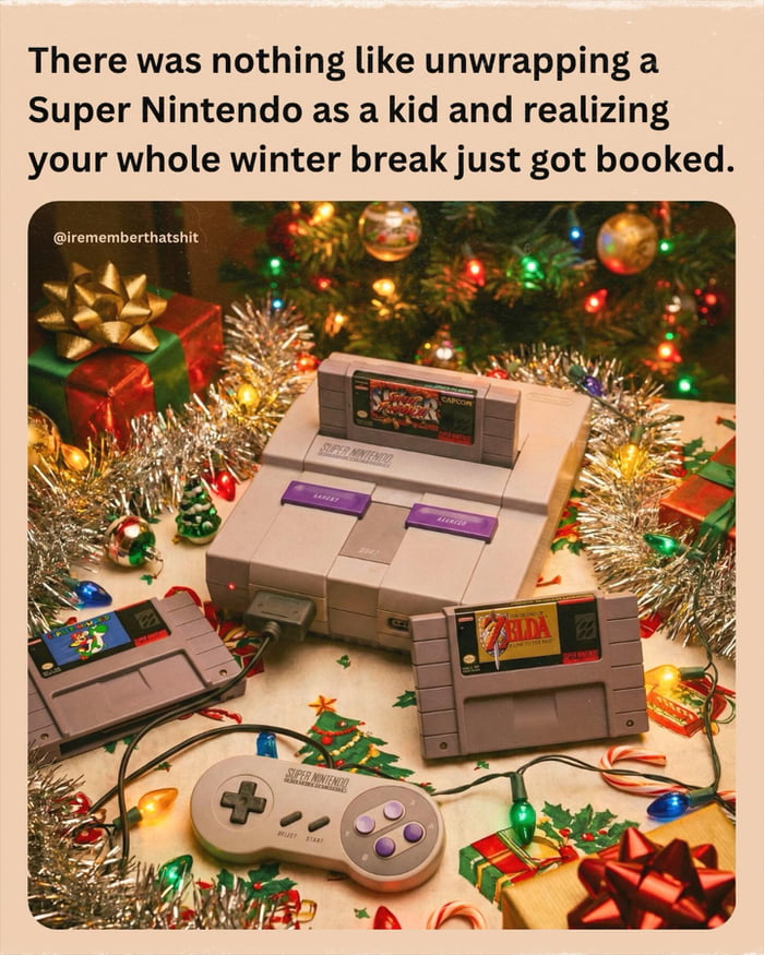 A nostalgic image featuring a Super Nintendo Entertainment System (SNES) console surrounded by Christmas decorations. The console is placed on a surface adorned with tinsel, colorful Christmas lights, small ornaments, and wrapped gifts with bows. Visible game cartridges include 'Super Mario World' (inserted into the console) and 'The Legend of Zelda' (lying next to the console). A SNES controller is also present. Above the image, there is text reading: 'There was nothing like unwrapping a Super Nintendo as a kid and realizing your whole winter break just got booked.' The scene evokes feelings of childhood nostalgia, holiday excitement, and the joy of receiving a beloved gaming console as a Christmas gift.