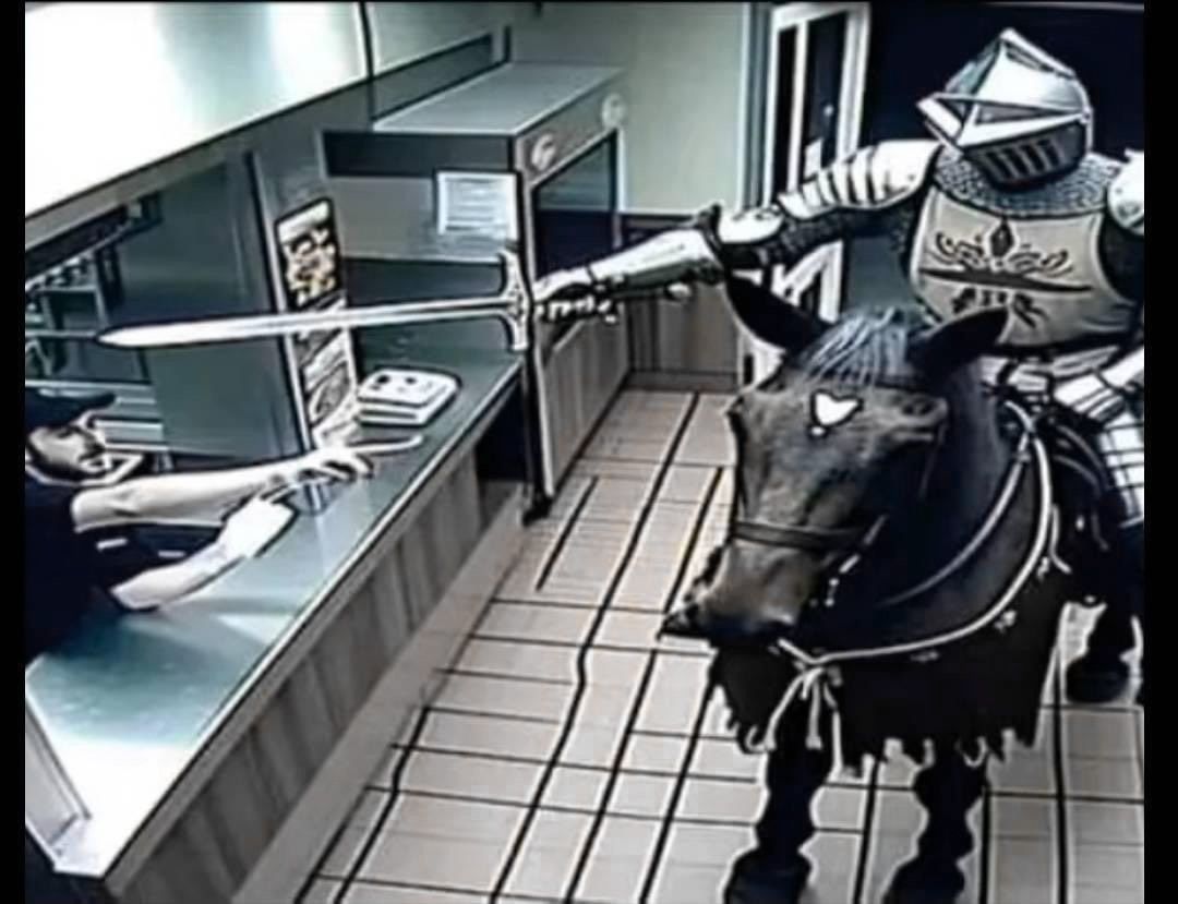 This is an absurdist composite meme showing a surreal anachronistic scenario: a fully armored medieval knight riding a dark horse is positioned inside a modern fast food restaurant, extending a longsword across the stainless steel service counter towards a fast food employee. The employee is leaning back from the counter with a shocked, alarmed, confused expression, clearly startled by the unexpected visitor. The setting includes typical fast food interior elements: menu displays, light square tiled flooring, and standard service counter fixtures. The humor comes entirely from the absurdity of a medieval armored figure on horseback appearing in a mundane contemporary dining environment, as if he has arrived to place an order or make a demand using his sword.