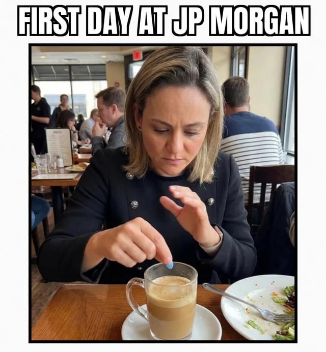 This is a single panel captioned meme. The base image shows a blonde woman in a black formal jacket sitting at a restaurant table, holding a small blue pill and about to drop it into a glass mug of coffee placed in front of her, with a half-eaten plate of salad next to the mug. Bold text at the top reads 'FIRST DAY AT JP MORGAN'. The joke leans on the widely acknowledged public perception that investment banking roles at firms like JP Morgan are extremely high-pressure and stressful, humorously implying that the new employee needs pharmaceutical coping mechanisms to get through her first day on the job.