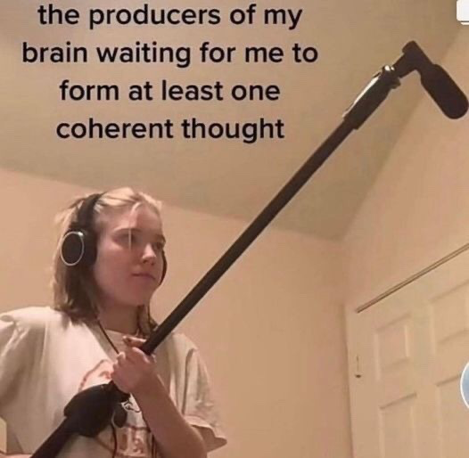 The image is a relatable humor meme showing a young blonde woman wearing over-ear headphones, holding a long boom microphone angled upward as if she is waiting intently to capture sound. Overlaid text at the top of the image reads 'the producers of my brain waiting for me to form at least one coherent thought', making a joking comparison between the experience of having brain fog or being unable to focus, and a film production crew waiting patiently to record content that never arrives.