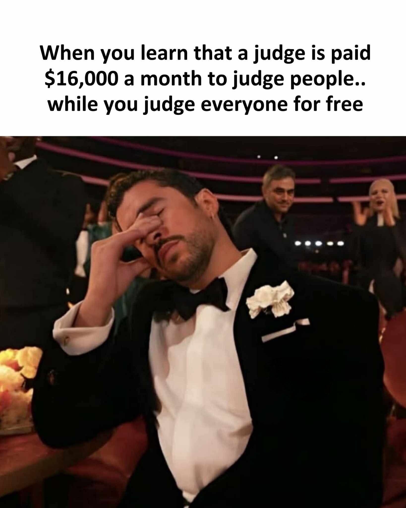 This meme consists of two parts: text at the top reads 'When you learn that a judge is paid $16,000 a month to judge people.. while you judge everyone for free'. Below the text is a widely used reaction photo of actor Rafael L. Silva, wearing a formal black tuxedo with a bow tie and a white boutonniere, holding his hand to his face with his eyes closed and an exasperated, regretful expression, as if he is just realizing he has been doing the same work as a professional judge for no compensation. Other event attendees are visible in the blurred background, indicating the photo was taken at a formal awards ceremony.