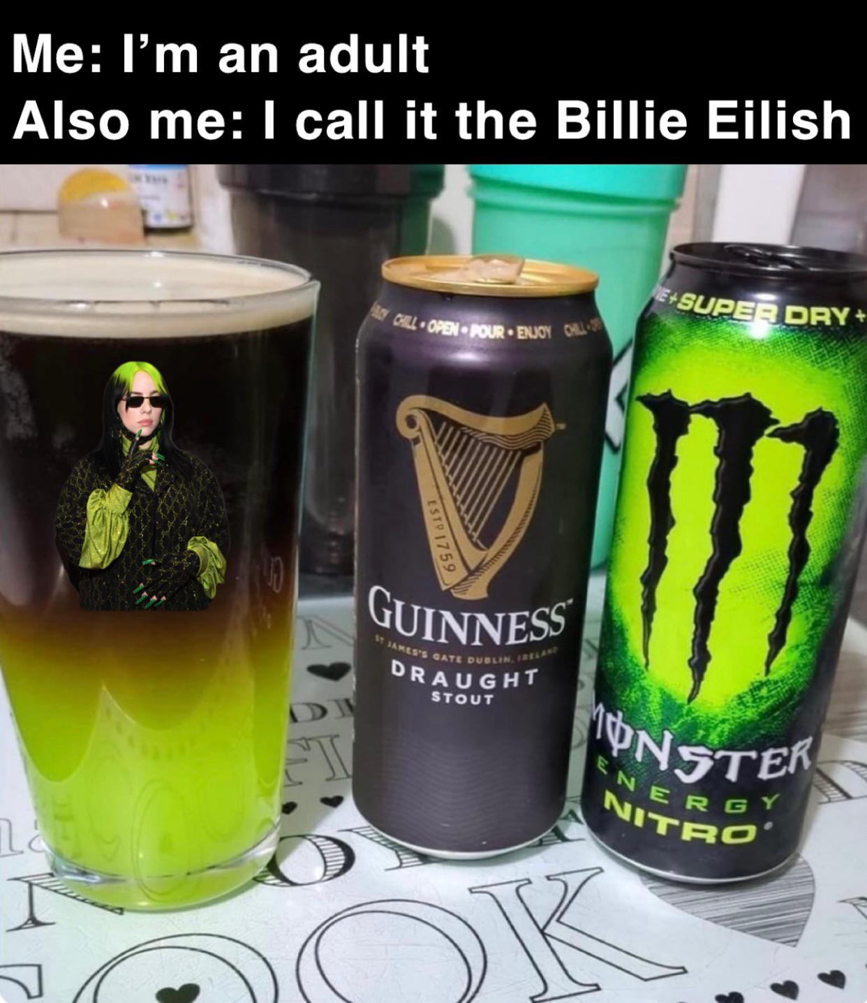 A meme featuring two text lines at the top: 'Me: I’m an adult' and 'Also me: I call it the Billie Eilish'. Below the text is a photograph of three items on a table: a glass filled with dark liquid (possibly beer or a mixed drink) displaying an image of Billie Eilish (green hair, sunglasses, black and green outfit), a black Guinness Draught Stout can with a gold harp logo, and a green Monster Energy Nitro can with the iconic 'M' logo. The humor lies in the contrast between claiming adulthood and playfully naming a drink after a celebrity, highlighting the relatable 'adulting' struggle of balancing maturity with silly habits.