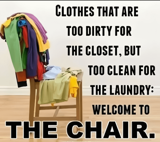 The image depicts a wooden chair positioned in a room with a light-colored wall and wooden flooring, piled with various colorful clothes including sweaters, shirts, and other garments. To the right of the chair, bold black text reads: 'CLOTHES THAT ARE TOO DIRTY FOR THE CLOSET, BUT TOO CLEAN FOR THE LAUNDRY: WELCOME TO THE CHAIR.' The meme humorously highlights the relatable household phenomenon of clothes that are not clean enough to return to the closet nor dirty enough for the laundry, thus accumulating on a chair.