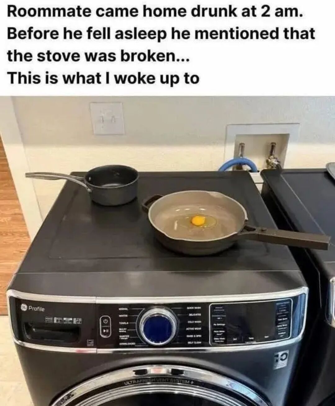 This meme depicts a funny silly situation involving a drunk roommate. The top text explains that the roommate came home drunk at 2 AM, told the poster the actual stove was broken before he passed out, and this image is what the poster found when they woke up. In the photo, a frying pan holding a cracked raw egg and a small saucepan are placed on the flat top surface of a front-loading GE Profile washing machine; the drunk roommate mistook the flat-topped washer for a working replacement stove.