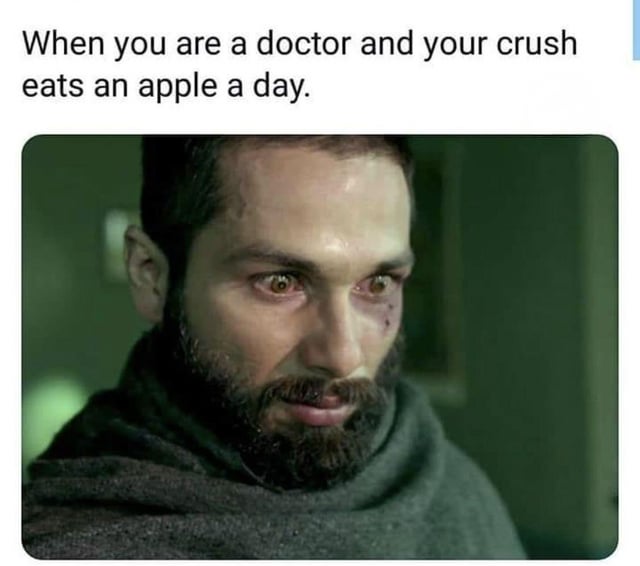 This single-panel reaction meme features top text above a still of a distraught, bearded man with minor facial injuries, teary eyes, and a devastated, defeated expression. The top text reads 'When you are a doctor and your crush eats an apple a day.' The joke relies on the common English idiom 'An apple a day keeps the doctor away', implying that the doctor's crush's daily apple consumption will prevent the doctor from being able to interact with or pursue her romantically, leaving him with zero chance of a relationship, matching the despair shown in the reaction image.