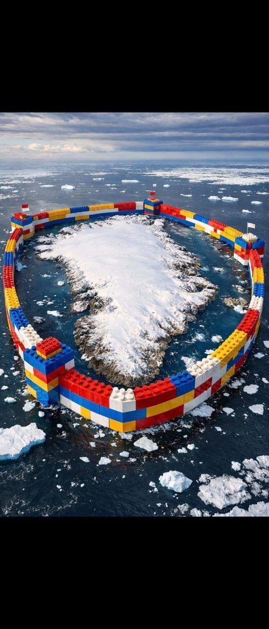 A digitally created image depicting a large, circular barrier constructed from colorful LEGO bricks (predominantly red, yellow, blue, and white) surrounding a snow-covered island in an icy ocean. The ocean is dotted with floating icebergs, and the sky is overcast with clouds, creating a cold, Arctic-like atmosphere. The LEGO structure forms a closed loop around the island, with small towers at intervals, humorously suggesting a defensive or protective barrier.