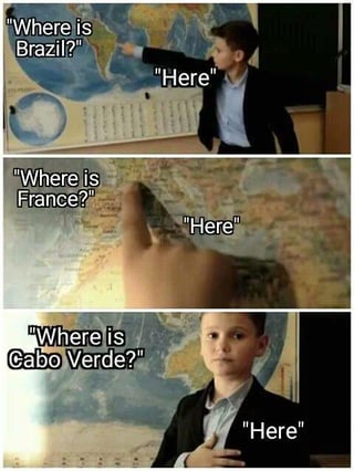 This is a 3-panel reaction meme. In the first panel, a young schoolboy wearing a blazer stands in front of a classroom world map, points correctly at the location of Brazil on the map when asked "Where is Brazil?", and responds "Here". In the second panel, he correctly points to the location of France on the map when asked "Where is France?", again responding "Here". In the third panel, when asked "Where is Cabo Verde?", instead of pointing at the map, he places his hand over his chest above his heart, and still answers "Here", implying that the small, often overlooked African island nation of Cabo Verde is held close in his heart as an expression of national pride and affection for the country.