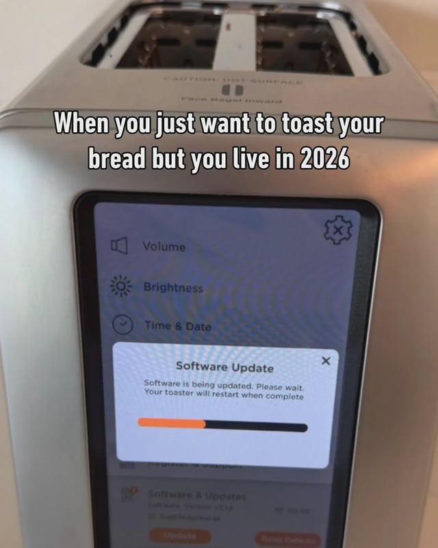 The meme shows a silver household toaster fitted with an integrated smart touchscreen display. A mandatory software update pop-up appears on the screen, reading 'Software is being updated. Please wait. Your toaster will restart when complete' alongside a partially filled progress bar. Overlaid on the upper part of the image is text that states 'When you just want to toast your bread but you live in 2026'. The joke is a satirical take on the growing trend of adding unnecessary internet-connected smart features and mandatory software updates to simple, low-tech household appliances, leading to frustrating user friction when people attempt to perform basic everyday tasks.