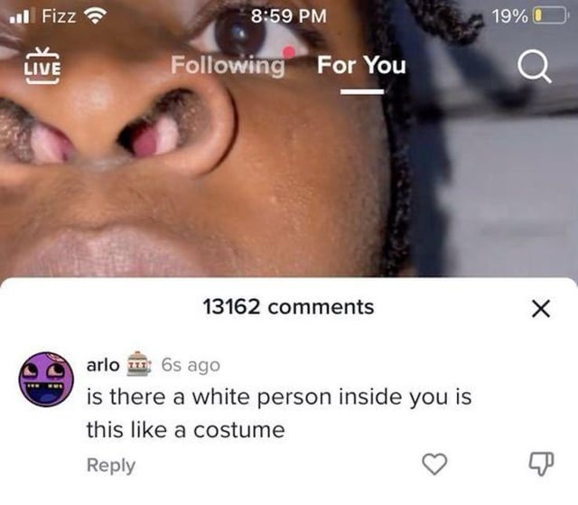 This image is a screenshot taken from the TikTok mobile app, showing an extremely close, upward-angled shot of a Black man's lower face (his nostrils, lips, part of one wide eye, and braided hair are visible) as the background. The TikTok For You page user interface is overlaid on top, including the device status bar, LIVE icon, and Following/For You navigation tabs. At the bottom, the comment section is open showing 13162 total comments, with a top comment from user 'arlo' that reads 'is there a white person inside you is this like a costume'. The meme highlights how unhinged, rude, and absurd comments left on TikTok videos can be, which aligns with its original title.