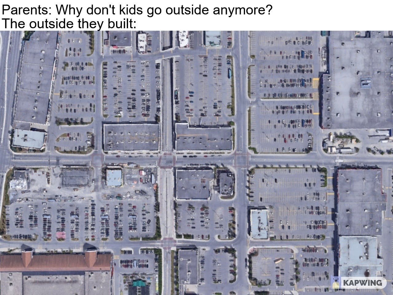 The meme uses a two-part joke structure: the top text quotes a common question from older generations, "Why don't kids go outside anymore?", followed by an aerial photograph of a typical North American suburban commercial district. The area shown is almost entirely dominated by massive parking lots, wide multi-lane roads, and low-rise box store buildings, with no visible pedestrian-friendly public spaces, green areas, or recreational locations for young people to gather. The humorous, critical punchline implies that the uninviting, car-focused built environment created by older generations is the actual reason kids prefer staying indoors instead of spending time outside.