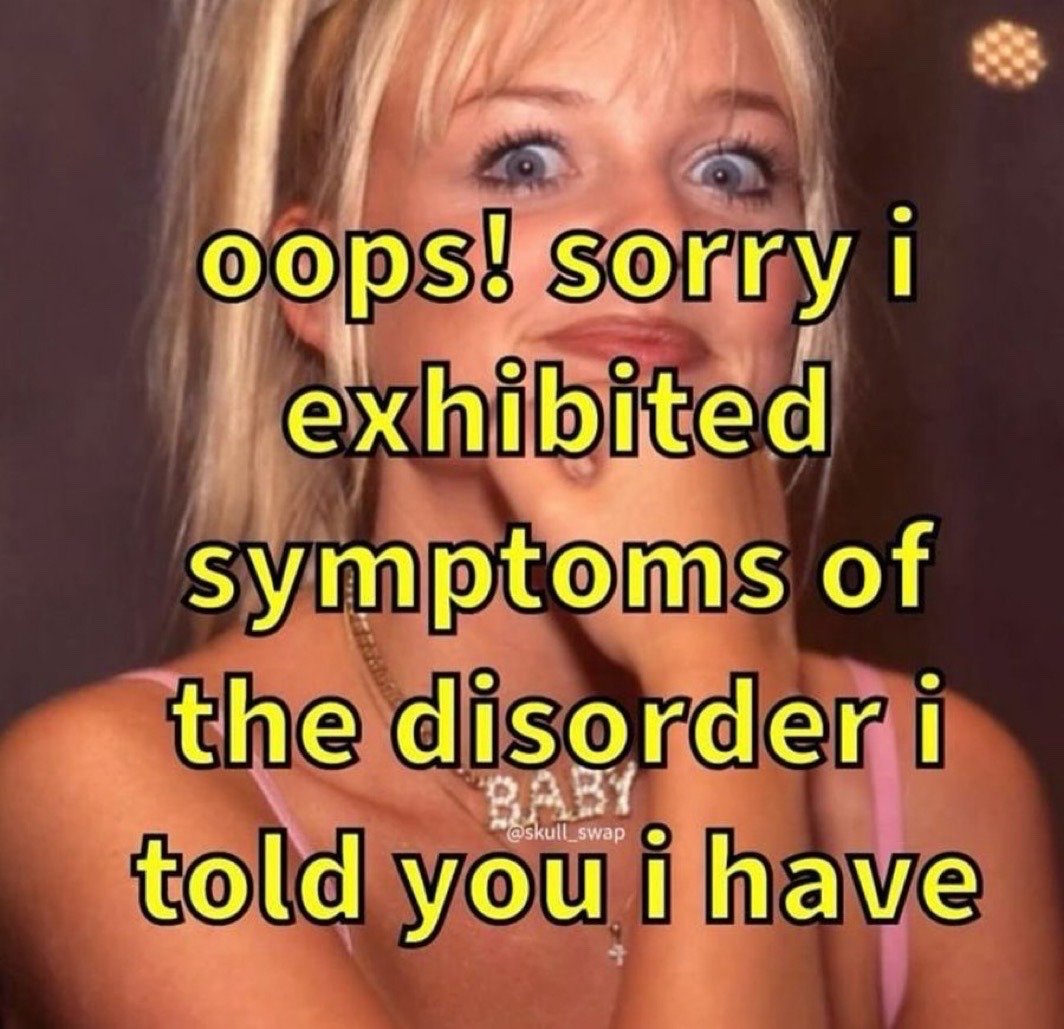 This is a relatable sarcastic reaction meme. It features a blonde young woman with wide shocked eyes, making an awkward guilty grimace while holding one hand up to her chin. She wears a pink tank top, a sparkly necklace reading "BABY", and a small cross necklace. Overlaid across the image in bold yellow text with a black outline is the joke text: "oops! sorry i exhibited symptoms of the disorder i told you i have". The humor is self-deprecating, referencing the relatable experience of playfully apologizing for acting in line with a mental or behavioral condition that one has already disclosed to others, even though exhibiting those symptoms is an expected, uncontrollable part of the condition.