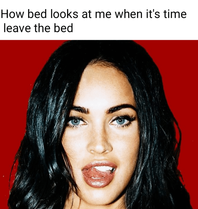 This is a relatable humorous meme that features a well-known portrait photograph of actress Megan Fox against a vibrant red background, where she is making a seductive, alluring face directly at the viewer while biting her lower lip. Text is overlaid at the top of the image, reading 'How bed looks at me when it's time leave the bed'. The joke personifies the bed as looking temptingly desirable when a person has to get up to start their day, capturing the very common, relatable feeling of not wanting to leave a comfortable, warm bed after sleeping.