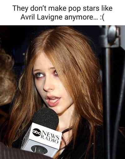 This meme has text at the top that reads 'They don't make pop stars like Avril Lavigne anymore... :(' placed above a vintage photograph of 2000s pop-punk icon Avril Lavigne during a press interview. Avril is shown with her signature dark smoky eye makeup, messy light brown hair, speaking into an ABC News Radio microphone while looking off to the side mid-sentence. The meme expresses nostalgia for the unique, edgy aesthetic and distinct persona of pop stars from the 2000s, implying that modern pop stars lack the same kind of iconic, memorable identity that Avril was famous for.