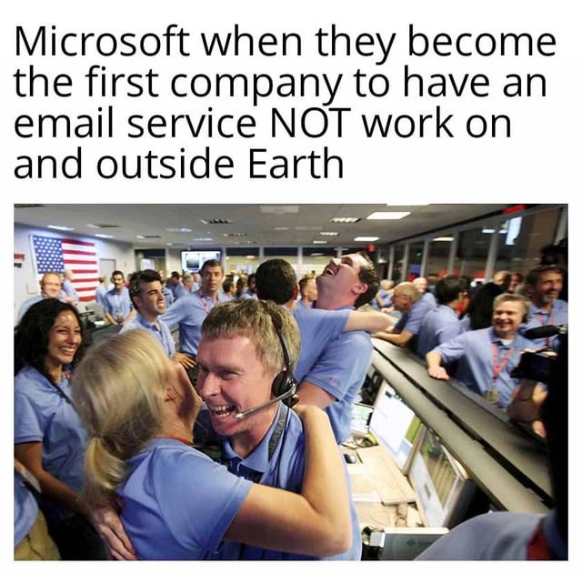 This is a single-panel image macro meme that uses the famous photograph of NASA mission control team members celebrating a successful space mission to make a sarcastic joke about Microsoft. The top text jokes that Microsoft is celebrating becoming the first company to have an email service that does NOT work even outside of Earth, poking fun at the widespread common complaint that Microsoft's email services (like Outlook) are unreliable and frequently malfunction even during regular use on Earth. The happy celebratory mood of the photo contrasts ironically with the negative, embarrassing achievement Microsoft is supposedly proud of, which amplifies the joke.