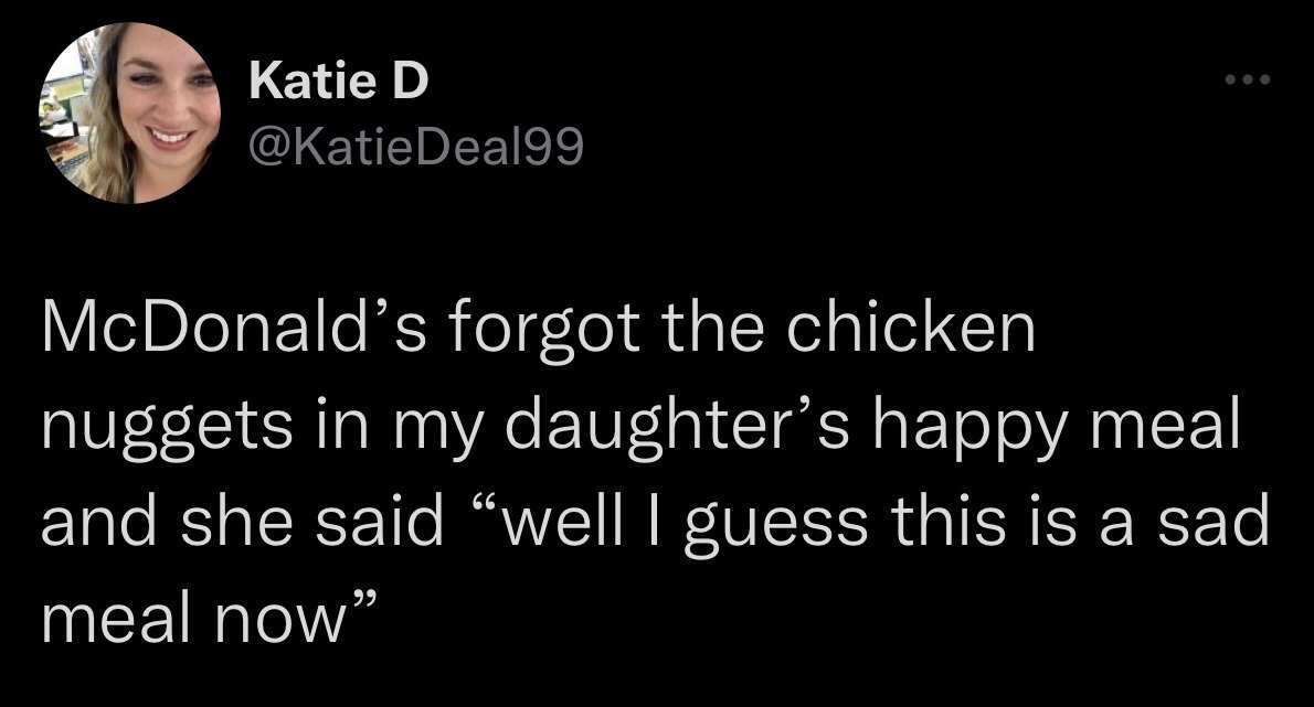 This image is a screenshot of a public X (formerly Twitter) post from user Katie D. The post recounts a humorous parenting anecdote: after McDonald's staff forgot to include chicken nuggets in the Happy Meal ordered for her daughter, the young girl made a pun by remarking that the incomplete order was now a 'sad meal', playing on the official 'Happy Meal' product name from McDonald's. The profile photo of the poster, a smiling woman, is visible in the top left corner alongside her username and handle.