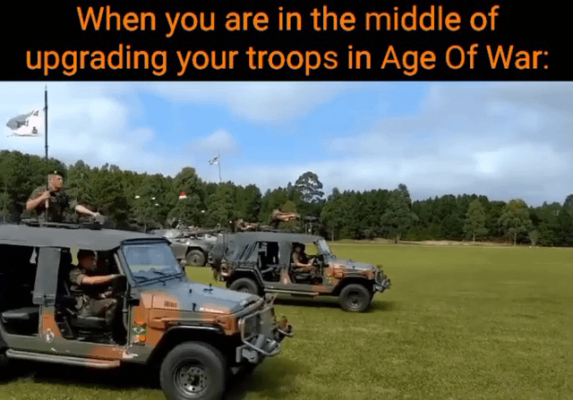 The meme features a top banner with orange text on a black background that reads 'When you are in the middle of upgrading your troops in Age Of War:'. Below the banner is a photograph of multiple camouflaged military jeeps parked on a wide green grassy field, with a dense forest line and partly cloudy blue sky in the background. Several uniformed soldiers are visible: one drives the front jeep, another stands on the roof of the front jeep holding equipment, and additional soldiers are seated in other jeeps further back. The joke references the classic Adobe Flash game *Age of War*, where players progress through different historical eras by upgrading their military units from primitive stone age fighters to modern, heavily armed military forces; the sight of advanced modern military vehicles in the image humorously represents the state of having fully upgraded to high-tier troops in the game.