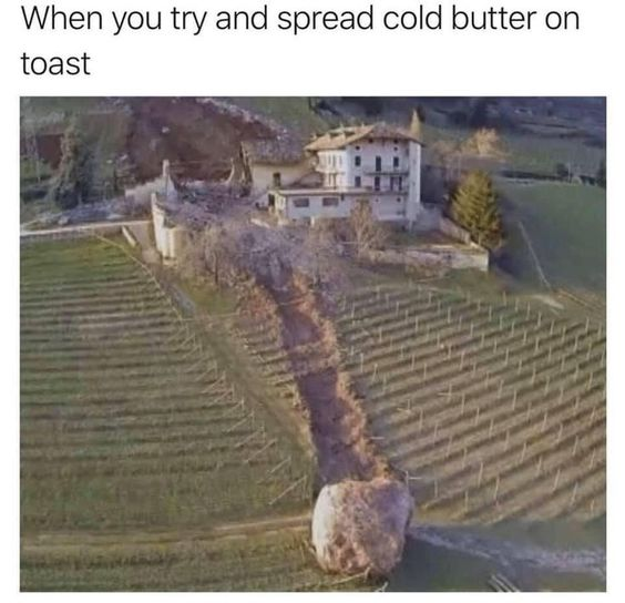 A meme featuring a photograph of a large boulder that has rolled down a hillside, creating a chaotic destructive trail through a terraced vineyard and damaging a nearby house. Above the image, the text reads 'When you try and spread cold butter on toast,' humorously analogizing the difficulty of spreading cold butter (which often tears or ruins toast) to the boulder's destructive path, as if the stiff butter is the boulder 'ruining' the toast (represented by the vineyard/house).
