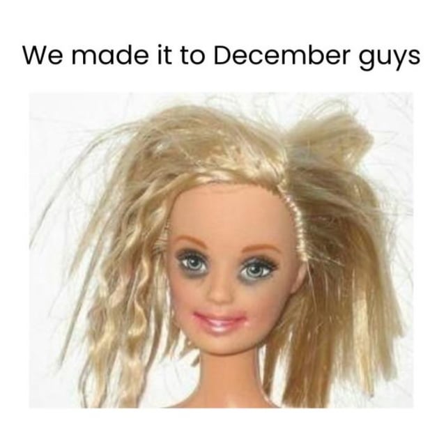 The meme features a top text overlay stating 'We made it to December guys' above a photograph of a doll. The doll has disheveled, unkempt blonde hair, large slightly glassy eyes, and a faint, weary smile. This combination humorously portrays the feeling of successfully reaching December after a long year, while visually representing the exhaustion and weariness that often accompanies the end of the year.