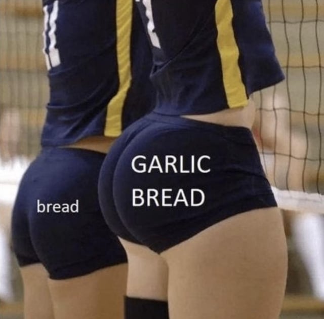 This edited meme image shows the rear view of two female volleyball players standing side-by-side beside a volleyball net, wearing matching navy and yellow athletic uniforms. The smaller, less prominent buttocks of the player on the left is labeled with the text 'bread', while the larger, rounder buttocks of the player on the right is labeled with large all-caps text reading 'GARLIC BREAD'. The humor comes from a visual pun that compares buttocks to bread, framing curvier, more desirable buttocks as garlic bread, which is widely considered a more delicious, preferred upgraded version of plain regular bread.