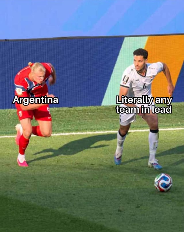 This meme uses a real photograph from an international football match featuring Norwegian striker Erling Haaland in a red kit, labeled 'Argentina', sprinting aggressively behind another opposing player in a white kit labeled 'Literally any team in lead' who is positioned near a loose football on the pitch. The joke plays on the widely recognized reputation of the Argentina men's national football team for staging dramatic come-from-behind victories over opponents who are leading during matches, particularly following their 2022 FIFA World Cup win.