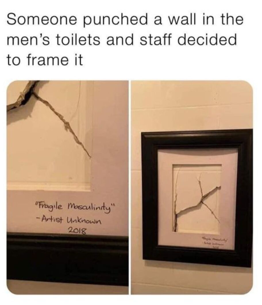 This two-panel meme shows the aftermath of someone punching and cracking a wall in a men's public restroom. Instead of repairing the damage, staff cut the cracked section of the wall out and mounted it in a black picture frame, labeling it as a modern art piece titled "Fragile Masculinity", credited to "Artist Unknown" dated 2018. The joke relies on double meaning: the word "frame" means both putting the damage in a picture frame, and framing/blaming the person who punched the wall, plus a humorous commentary on the concept of fragile masculinity, where angry outbursts like punching walls are stereotyped as a display of that.