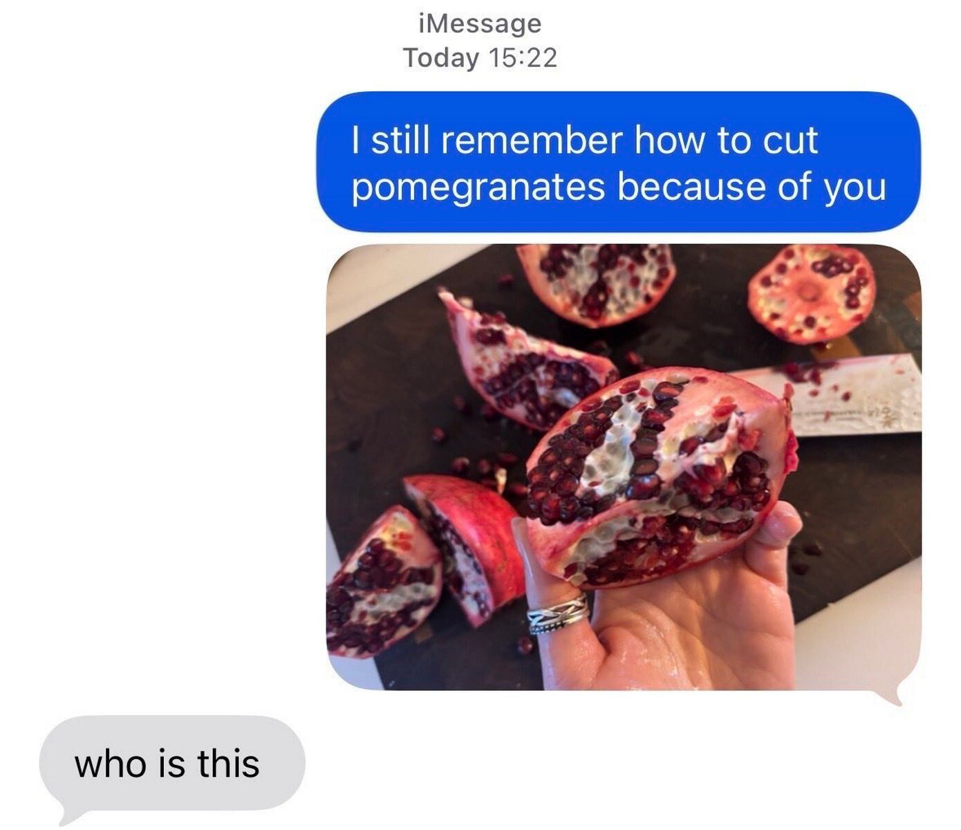 An iMessage screenshot featuring a humorous interaction. The top blue message bubble reads, 'I still remember how to cut pomegranates because of you,' accompanied by a photo of a hand holding a freshly cut pomegranate with several pieces scattered on a black cutting board. Below, a gray message bubble responds with, 'who is this,' creating a comedic contrast between the nostalgic sentiment and the recipient's confusion about the sender's identity. The image combines text and a real photo to highlight an awkwardly funny moment of misremembered connections.