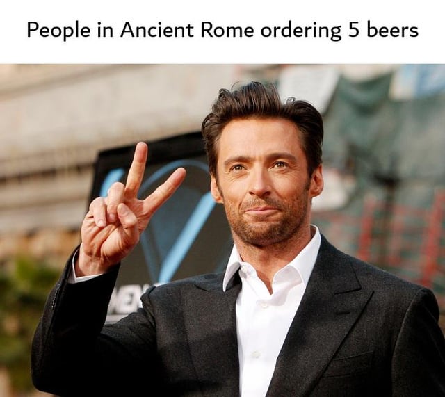 This meme features a red carpet photo of actor Hugh Jackman holding up a two-finger V/peace sign, paired with text above that reads 'People in Ancient Rome ordering 5 beers'. The joke relies on a historical pun: the Roman numeral for the number 5 is 'V', which is exactly the shape of the hand gesture Jackman makes, humorously implying ancient Romans would use this gesture to order 5 drinks in an anachronistic casual scenario.
