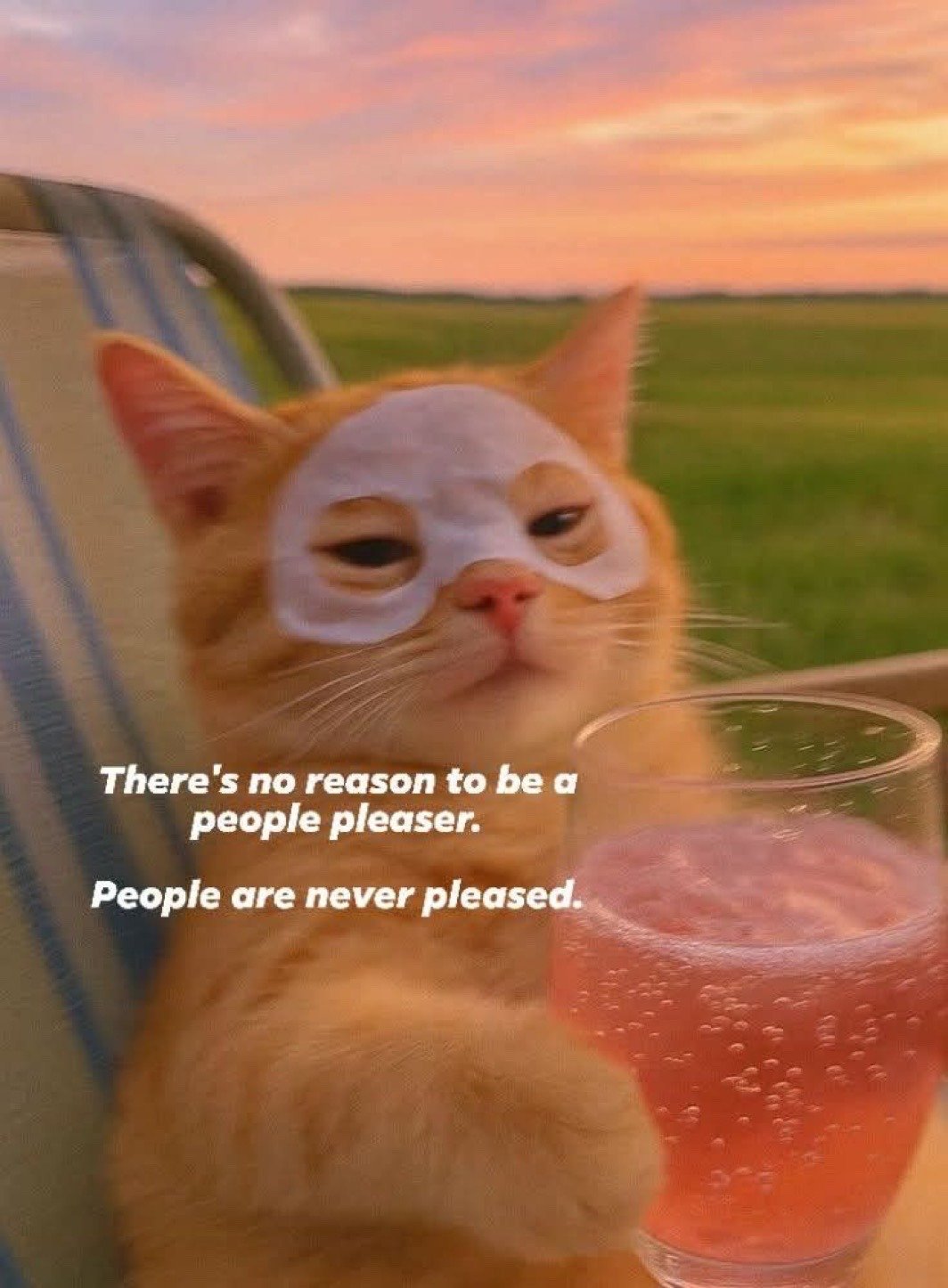 The image features an orange tabby cat sitting relaxed on a striped outdoor lounge chair against the backdrop of a grassy field under a warm pink and orange sunset sky. The cat is wearing a white cosmetic under-eye face mask, looking calm, unbothered, and slightly smug, with a glass of fizzy pink drink placed next to its paw. Overlaid white text reads two lines: 'There's no reason to be a people pleaser. People are never pleased.' The meme humorously pairs the cat's indulgent self-care routine with blunt, relatable advice about setting boundaries and not overexerting yourself to satisfy others, as it is impossible to make everyone happy all the time.