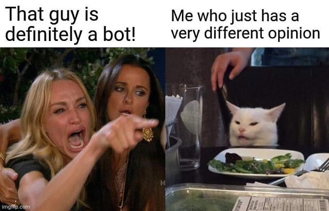 This is a two-panel reaction meme using the iconic 'Woman Yelling at a Cat' template. The left panel shows two women from The Real Housewives of Beverly Hills, with one screaming angrily and pointing aggressively, paired with the caption 'That guy is definitely a bot!'. The right panel shows Smudge the unimpressed white cat sitting at a dinner table, paired with the caption 'Me who just has a very different opinion'. The joke highlights the common frustrating online experience where users are falsely accused of being automated bots solely for holding an opinion that differs from the majority in a discussion thread.