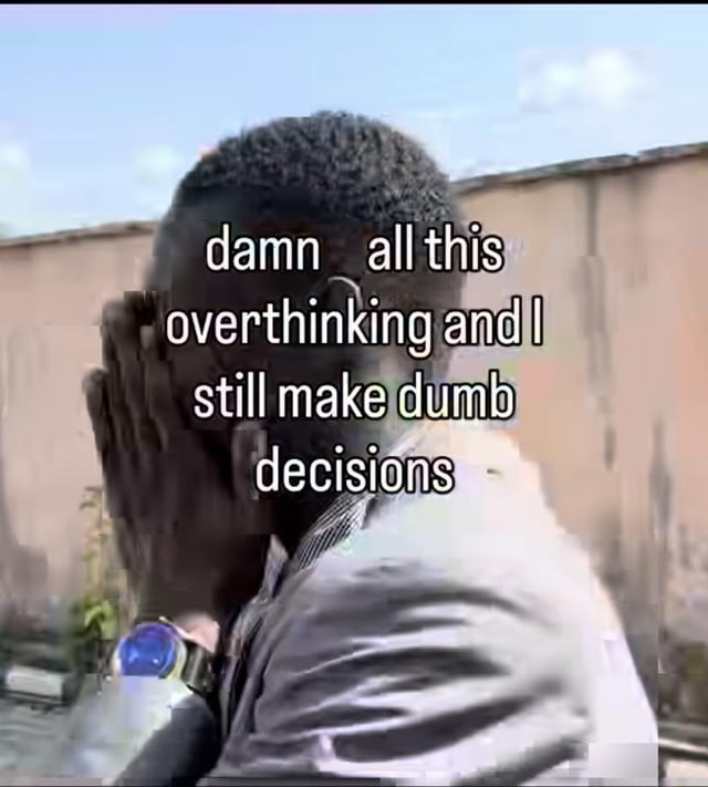 This is a relatable reaction meme featuring a real Black man holding his face in his hand, hunched over in frustration. Overlaid text across the image reads 'damn all this overthinking and I still make dumb decisions', which perfectly captures the common frustrating experience of spending a lot of time over-analyzing a choice, only to end up making a bad decision anyway.