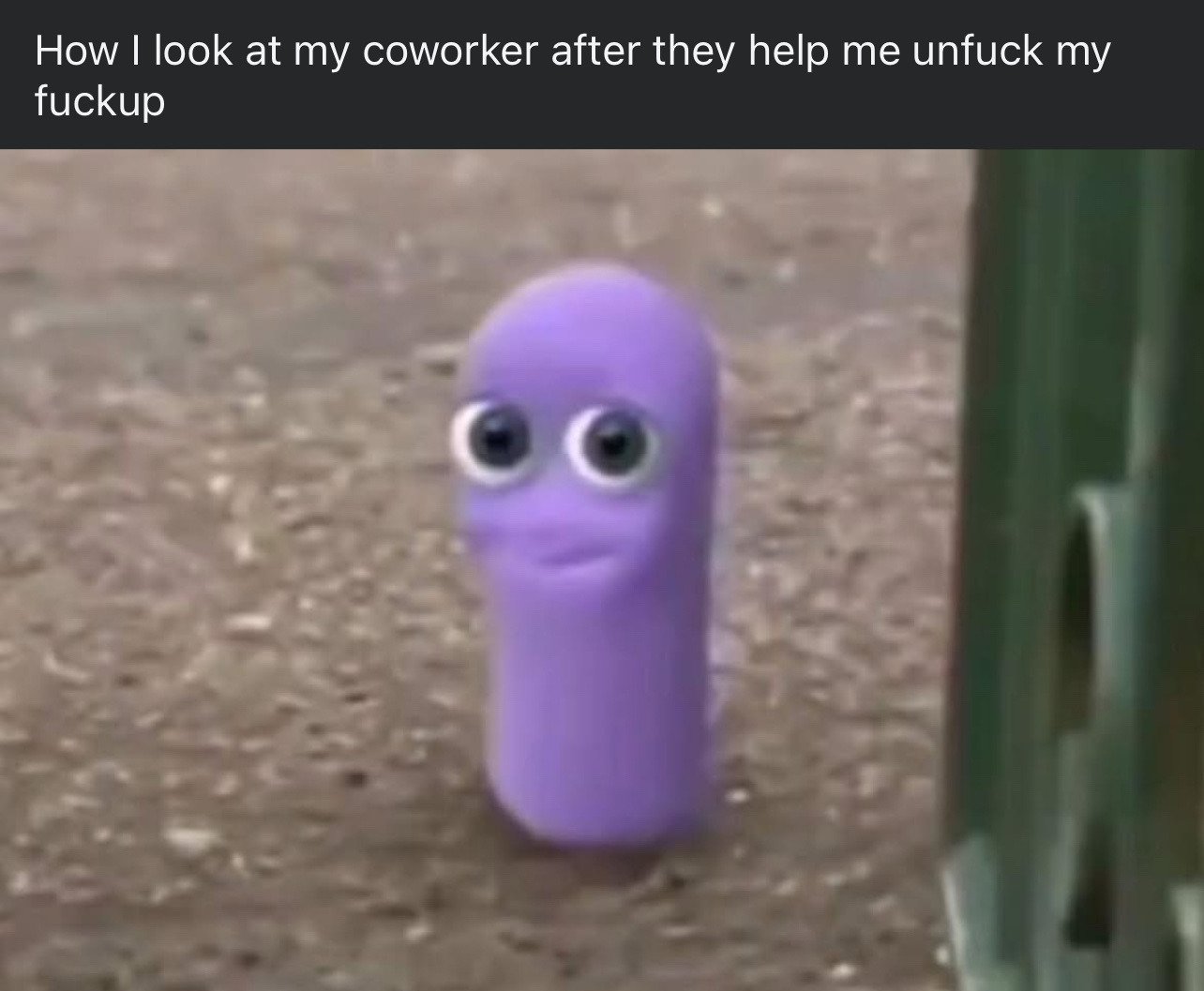 The meme features a top text overlay placed above a blurry photo of a small purple worm-shaped Beanz toy with large googly eyes and a soft, gentle smile, positioned on a rough brown dirt surface. The text humorously illustrates the sheepish, overwhelmingly grateful expression someone has when a coworker helps them fix a major mistake they made at work.