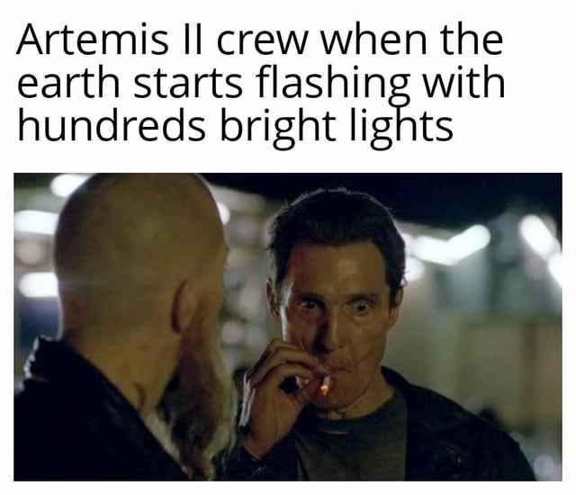 This is a humorous meme that imagines the reaction of the Artemis II moon mission crew when they look back towards Earth from space, and see hundreds of bright flashing lights coming from the planet. The joke refers to the fact that thousands of people on Earth would all take photos of the passing Artemis II rocket, creating a massive flash of lights that would look alarming from space. The meme uses the popular reaction image of actor Matthew McConaughey as Joseph Cooper in the film *Interstellar*, with a shocked, wide-eyed confused expression while smoking a cigarette, to perfectly convey this surprised, alarmed reaction.