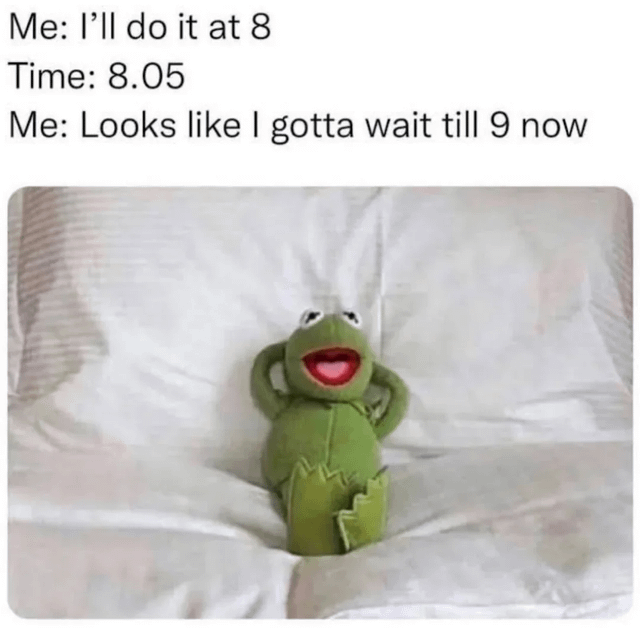 This meme depicts the common relatable experience of procrastination. The top text describes a scenario where someone plans to complete a task at 8, notices the time is 5 minutes past 8, and decides to delay the task until 9 instead of starting immediately. Below the text is a photo of a Kermit the Frog plush toy leaning back against bed pillows with his hands behind his head, looking relaxed and unbothered, perfectly illustrating the laid-back, avoidant attitude of someone procrastinating their responsibilities.