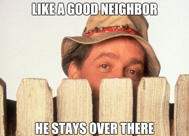 A meme image featuring a real person peeking over a wooden fence, with two lines of bold white text. The top text reads 'LIKE A GOOD NEIGHBOR' and the bottom text reads 'HE STAYS OVER THERE'. The image humorously parodies the Allstate insurance slogan 'Like a good neighbor, Allstate is there' by subverting it to suggest a nosy neighbor should stay on their own side, adding a sarcastic twist to the concept of being a 'good neighbor'.