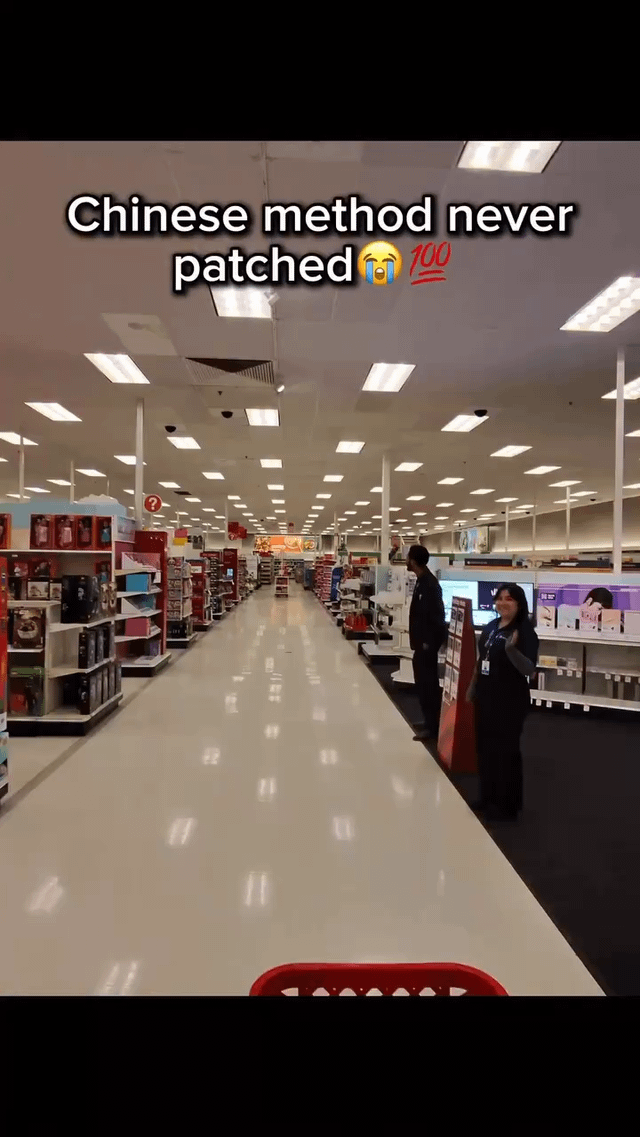 A photograph capturing a brightly lit retail store aisle with neatly arranged shelves stocked with various products on both sides. The floor is highly reflective, and the ceiling is lined with numerous fluorescent lights. Two store employees are present: one standing near the shelves on the right side, appearing to observe, and another closer to the camera on the right, gesturing with their hand. Overlaid text at the top reads 'Chinese method never patched😆💯', where 'patched' likely references fixing a loophole or trick, implying a humorous, enduringly effective 'method' associated with Chinese people.