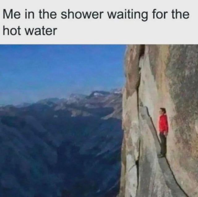 A meme featuring a top text caption 'Me in the shower waiting for the hot water' combined with an image of a person standing precariously on a narrow cliff edge with a steep mountain drop below. The humor arises from the exaggerated contrast between the mundane, everyday situation of waiting for hot water and the dramatic, high-stakes visual of being in a dangerous, tense position on a cliff, mocking the impatience or perceived 'agony' of waiting for hot water to start during a shower.