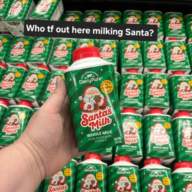 A photograph depicting a hand holding a green and red 'Santa's Milk' whole milk carton by DairyPure, with a background of shelves stocked with identical cartons. The carton features an illustration of Santa Claus jollily holding a glass of milk. Prominently overlaid at the top of the image is the text 'Who tf out here milking Santa?', which plays on the double meaning of 'milking'—both the literal extraction of milk and the colloquial sense of exploiting someone, creating a humorous and suggestive implication tied to the original Reddit title referencing Mrs. Claus.