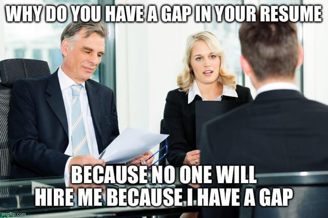 The meme depicts a standard job interview scene: two formally dressed interviewers (an older man holding a resume and a blonde woman holding a folder) sit across from a male job applicant whose back is turned to the viewer. The top overlaid text shows the common intrusive interview question: 'WHY DO YOU HAVE A GAP IN YOUR RESUME', while the bottom text is the applicant's unspoken, frustrated, ironic response: 'BECAUSE NO ONE WILL HIRE ME BECAUSE I HAVE A GAP'. It highlights the absurd, cyclical catch-22 faced by unemployed people looking for work, where having an employment gap on a resume makes it harder to get hired, which in turn extends the employment gap further, creating a vicious cycle that is difficult to escape.