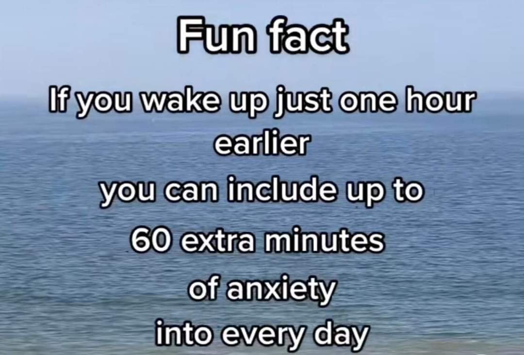 This meme uses a tranquil, serene background of a calm blue ocean stretching to the horizon under a pale, clear blue sky, overlaid with bold white text with thick black outlines for readability. The text presents a sarcastic 'fun fact' that subverts common mainstream self-help advice: it claims that waking up one hour earlier does not grant you extra productive time, but instead adds up to 60 additional minutes of anxiety to each day. The joke is rooted in the relatable experience of people with anxiety, who often have more time to ruminate, overthink, and worry when they wake up earlier than required.