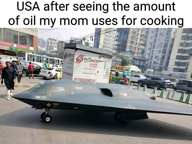 A humorous meme featuring a photoshopped image of a large B-2 stealth bomber placed in an urban street scene. The top text reads 'USA after seeing the amount of oil my mom uses for cooking,' creating a comedic exaggeration where the USA (represented by the military aircraft) reacts dramatically to the relatable scenario of a mom using a significant amount of cooking oil. The street scene includes pedestrians, cars, and a small structure with non-English text (possibly Bengali), suggesting a South Asian urban environment. The juxtaposition of the military aircraft in a mundane setting amplifies the absurdity and humor of the reaction.