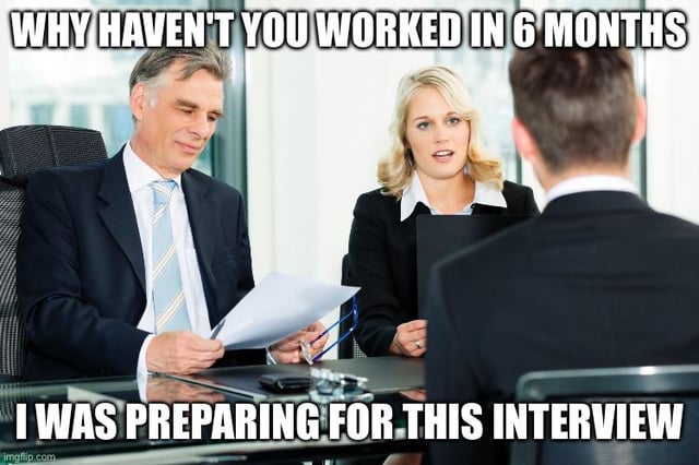 This is a single-panel stock photo meme depicting a standard corporate job interview scenario. Two interviewers: an older gray-haired man in a dark suit with a light blue striped tie, and a blonde woman in a black blazer with a white collared shirt, sit across a glass conference table from a male job candidate whose back is turned to the viewer. The top caption, representing the interviewers' question, reads "WHY HAVEN'T YOU WORKED IN 6 MONTHS". The bottom caption, the candidate's humorous, defiant response, reads "I WAS PREPARING FOR THIS INTERVIEW". The joke leans into wish fulfillment for job seekers, who often face uncomfortable questions about gaps in their employment history and wish they could give an unfiltered, snarky answer instead of the professionally appropriate expected response. An Imgflip watermark is visible in the bottom left corner.