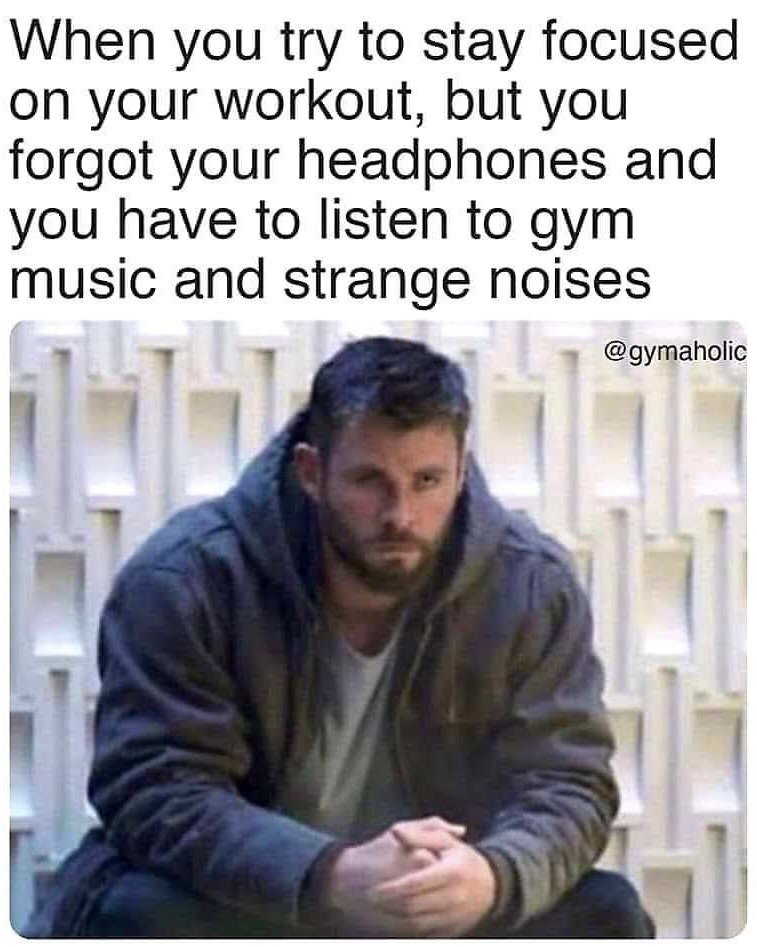 The meme features a top text section placed above a still image of Chris Hemsworth portraying a glum, defeated Thor from *Avengers: Endgame*. The text reads "When you try to stay focused on your workout, but you forgot your headphones and you have to listen to gym music and strange noises", pairing the character's miserable, frustrated expression with the common relatable annoyance of being forced to listen to unpleasant background sounds at the gym when one forgets their personal headphones, perfectly capturing the frustration of that common gym scenario.