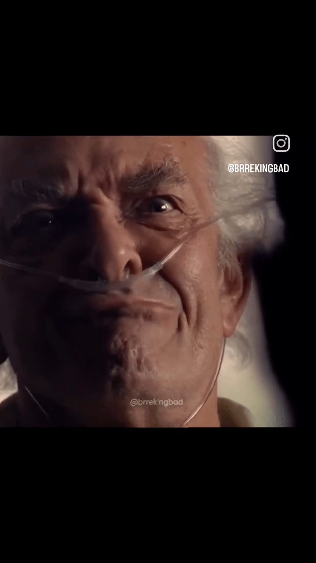 A close-up screenshot of an elderly man with white hair, wearing a nasal cannula (oxygen tube), displaying an intense and serious expression. The lighting is dim, focusing on his face to emphasize emotional depth. The image contains Instagram watermarks: '@BRREKINGBAD' in the top right corner with the Instagram logo, and '@brrekingbad' at the bottom center, indicating it was shared on Instagram. The man's furrowed brows and fixed gaze suggest a dramatic or pivotal moment from a TV show.